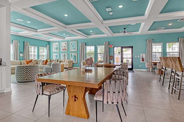 A large wooden table surrounded by chairs in a room with a blue ceiling.